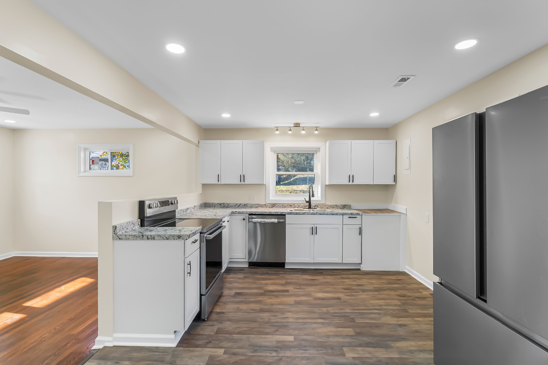 New kitchen with white shaker cabinets, marbled counters, and stainless appliances