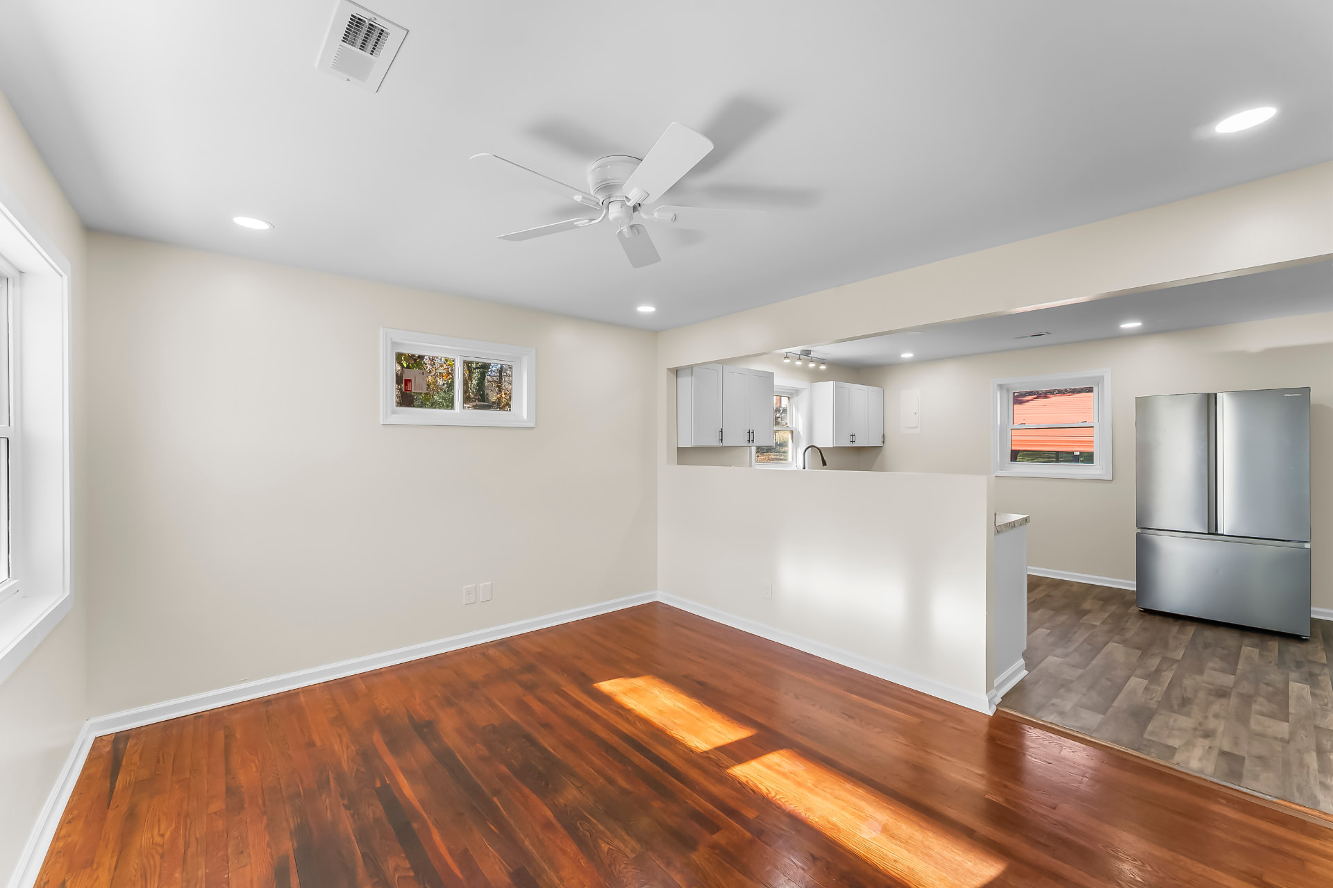 Living room with refinished hardwood floors open to the new kitchen