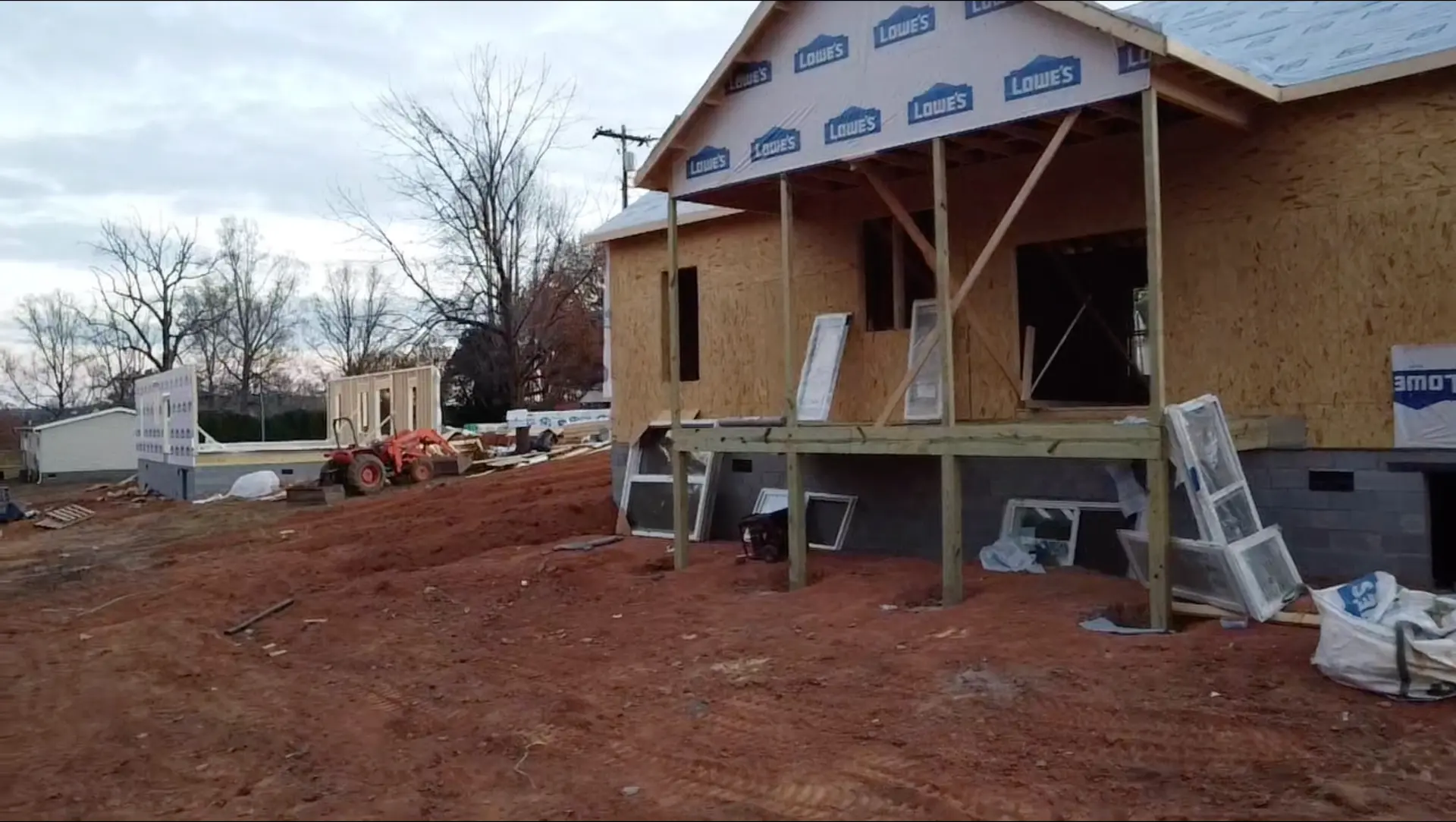 Framed home with sheathing, house wrap, and covered front porch posts in place