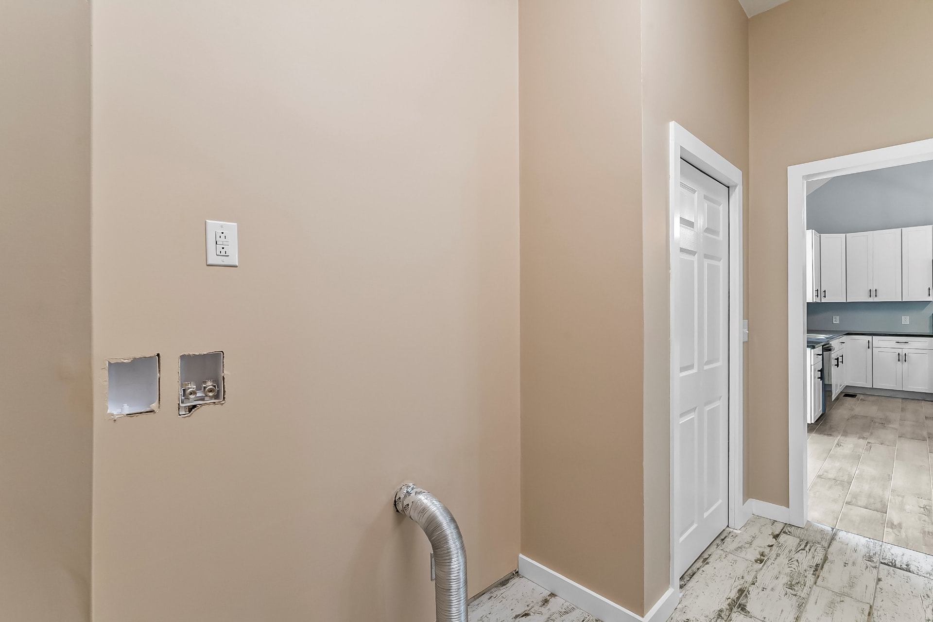 Laundry room with washer and dryer hookups opening into the kitchen