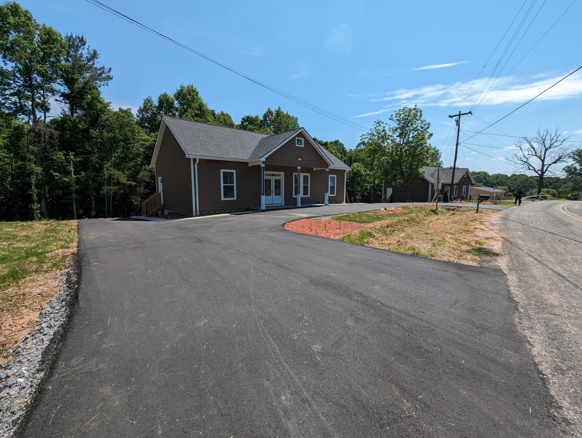 Street view of both completed homes with new paved driveways and mulched beds
