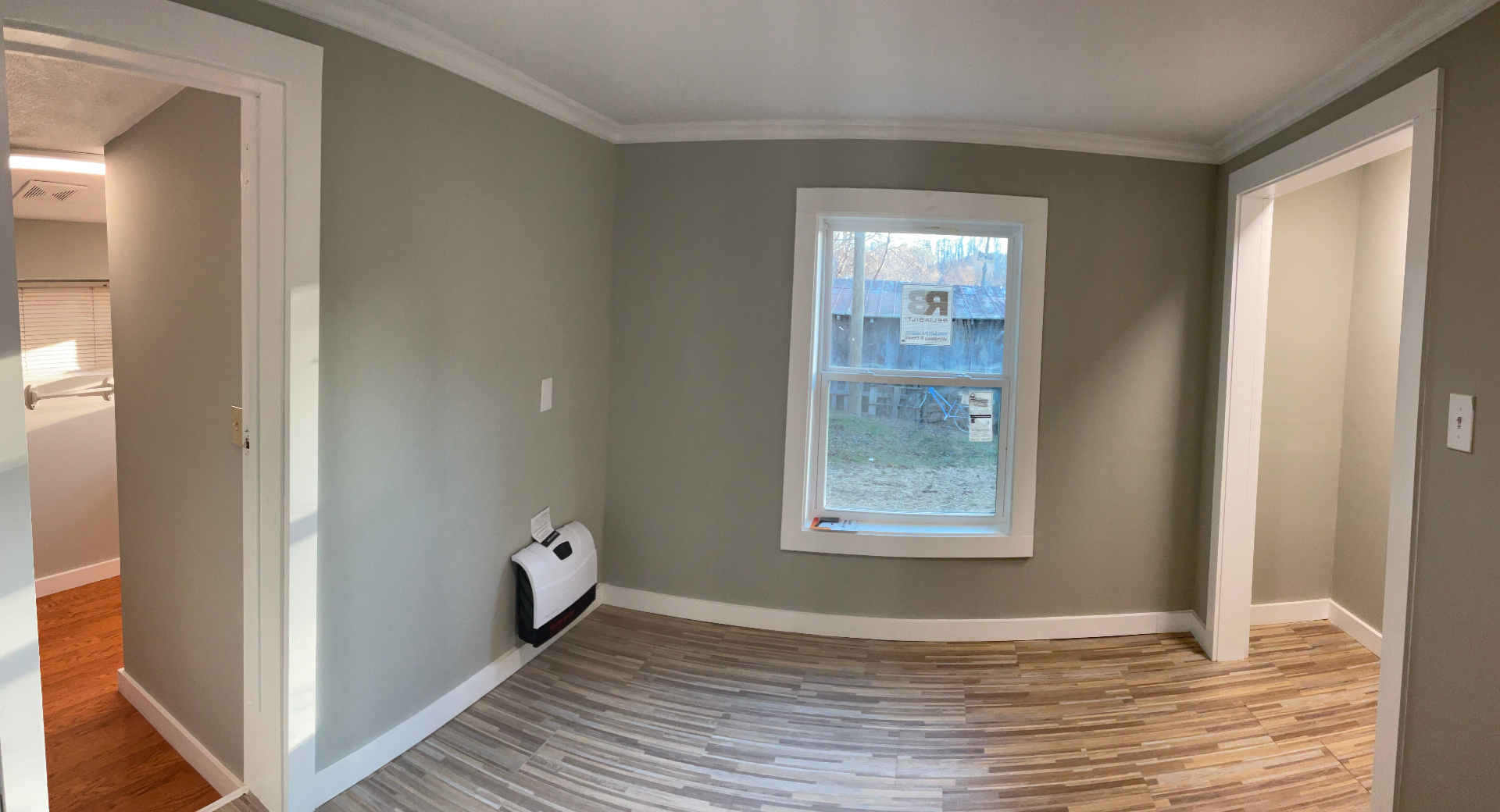 Bedroom with fresh paint, crown molding, new window, and wood-look flooring