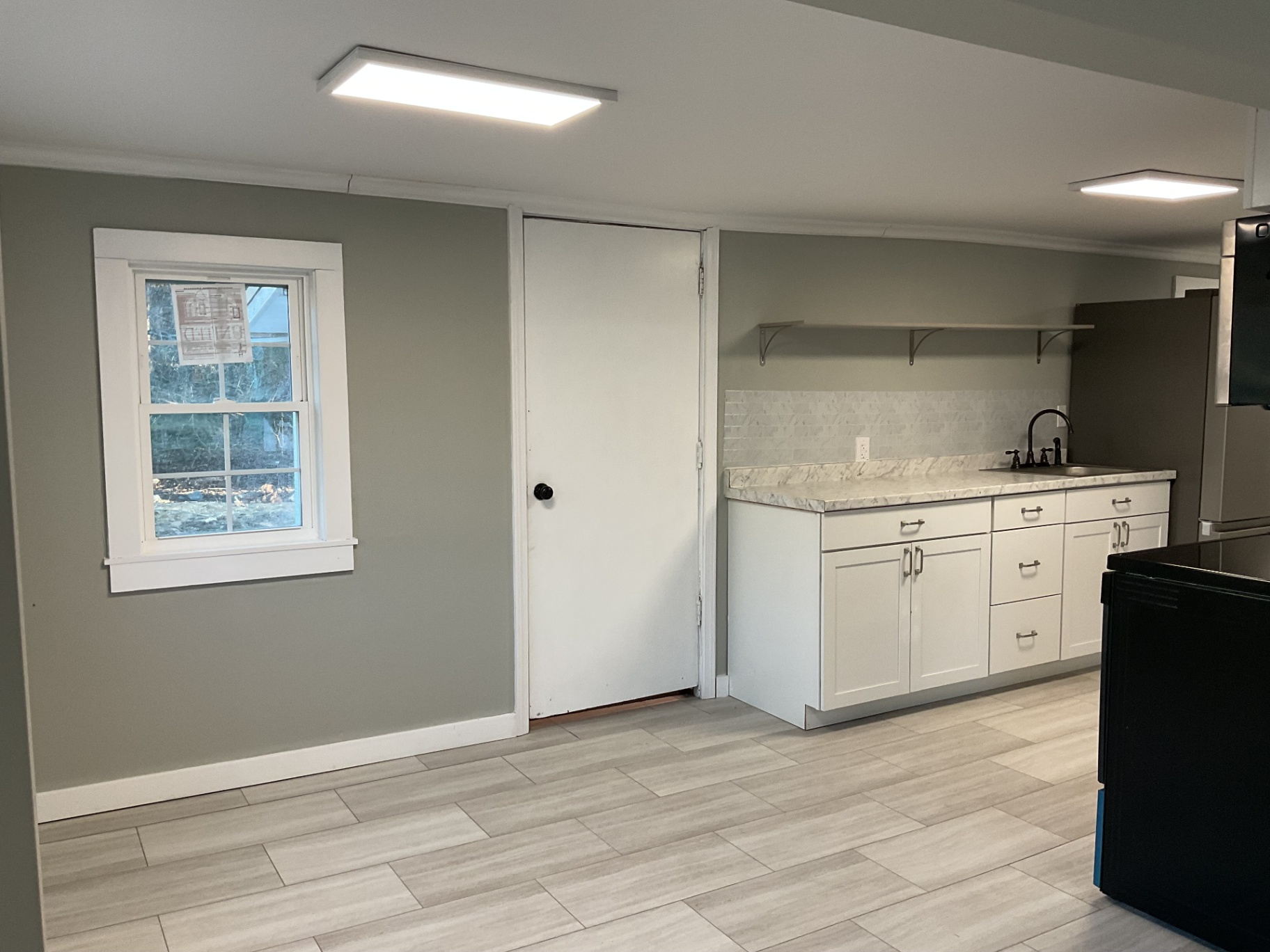 Kitchenette with white shaker cabinets, marbled countertop, tile backsplash, and open shelving