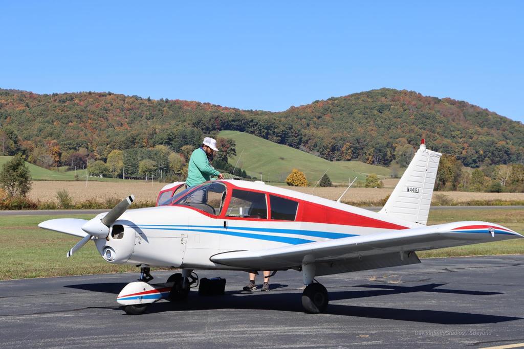 Taha preparing a small single-engine airplane on a mountain airstrip