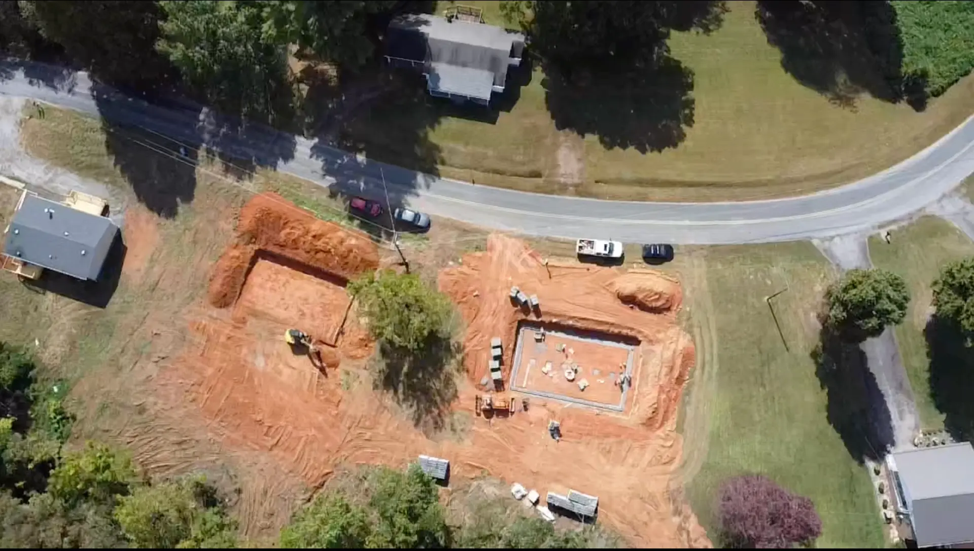 Aerial view of two new home sites with footings dug and the first foundation poured