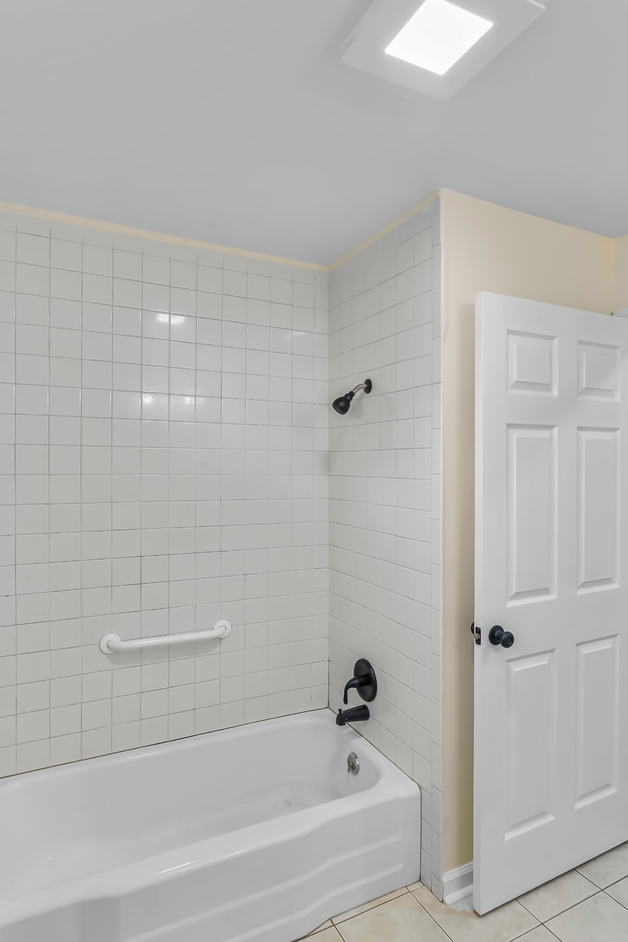 Refreshed tiled tub and shower with matte black fixtures