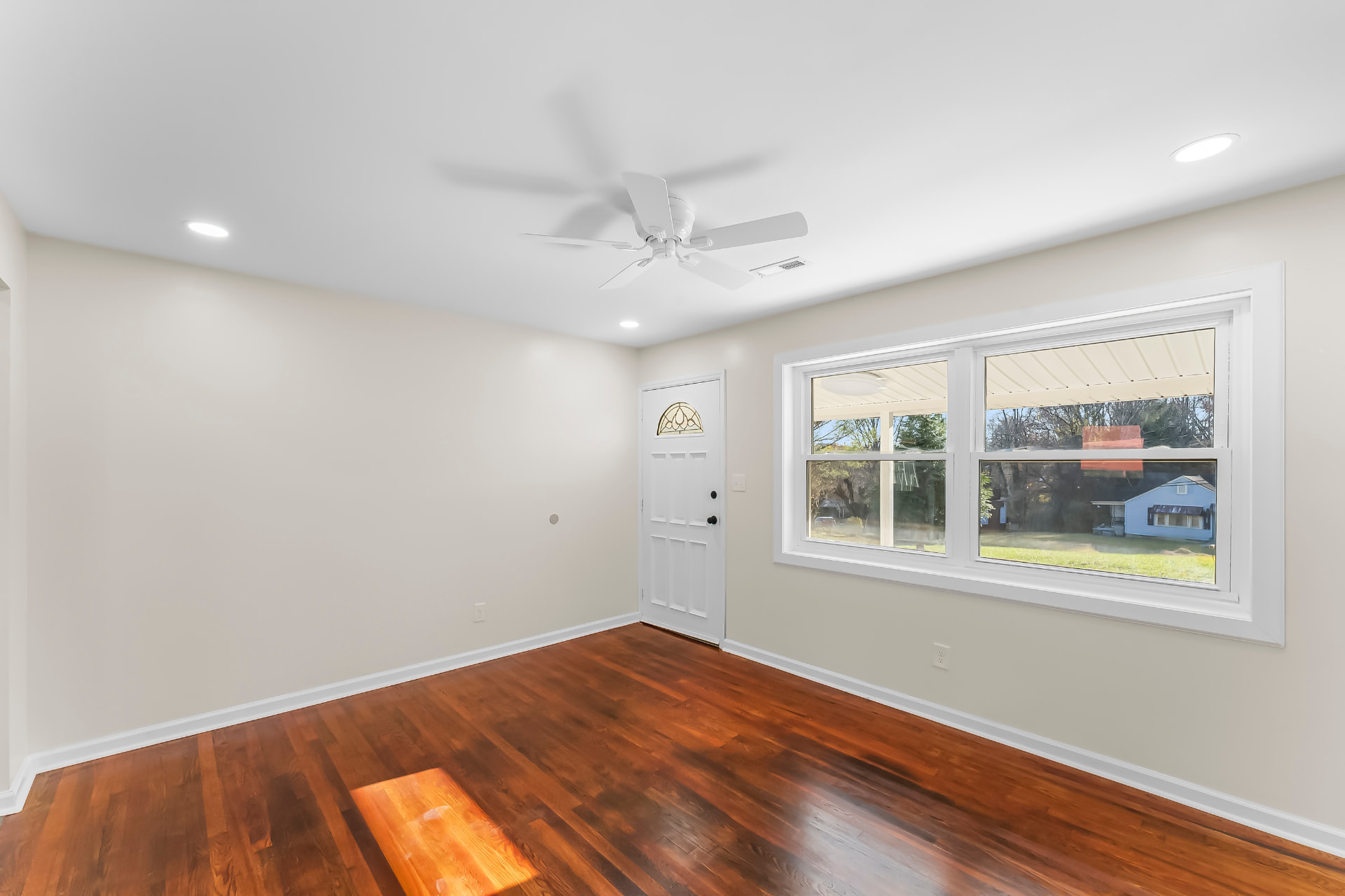 Front living space with large new window, fresh paint, and ceiling fan