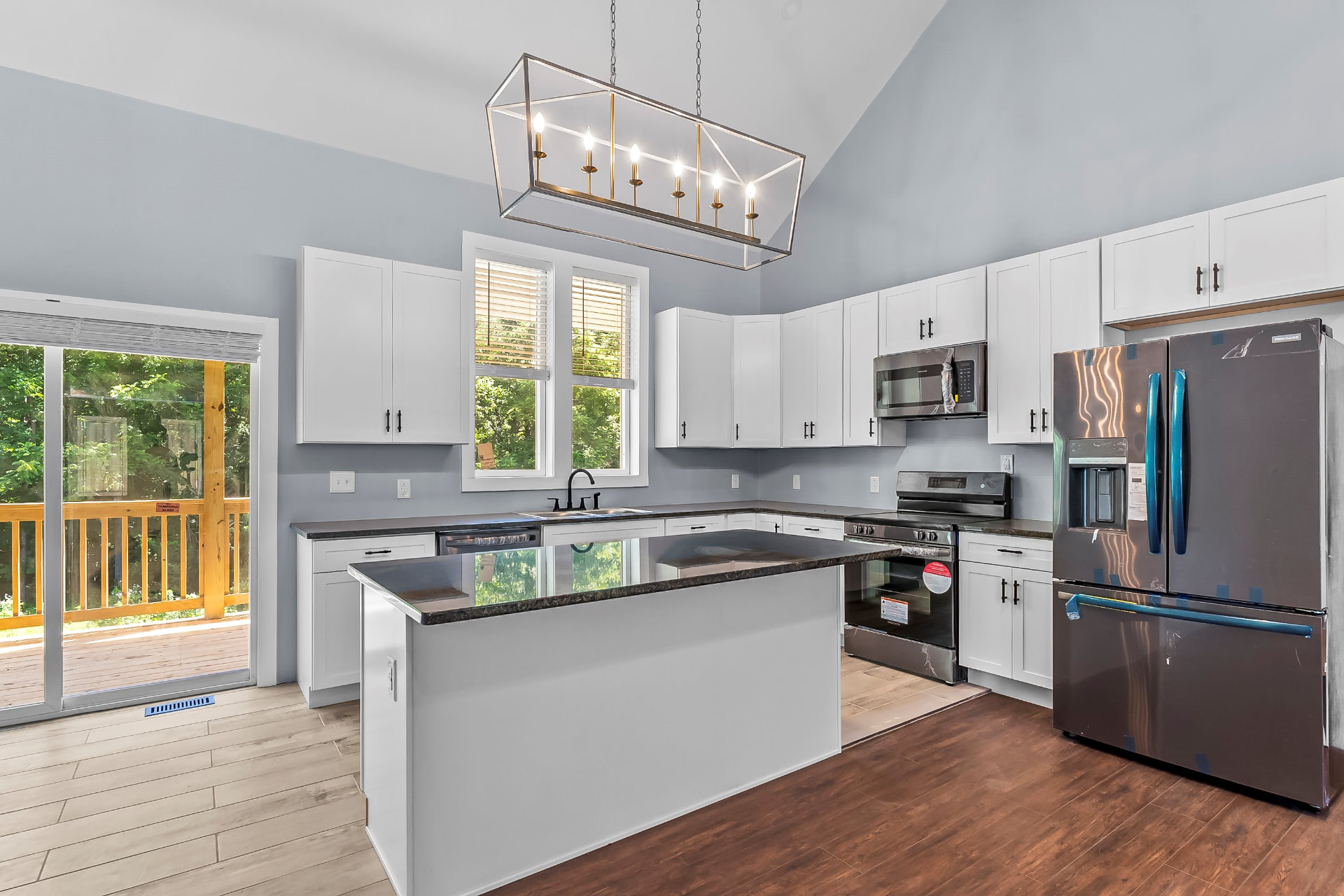 New kitchen with white shaker cabinets, granite island, and stainless appliances