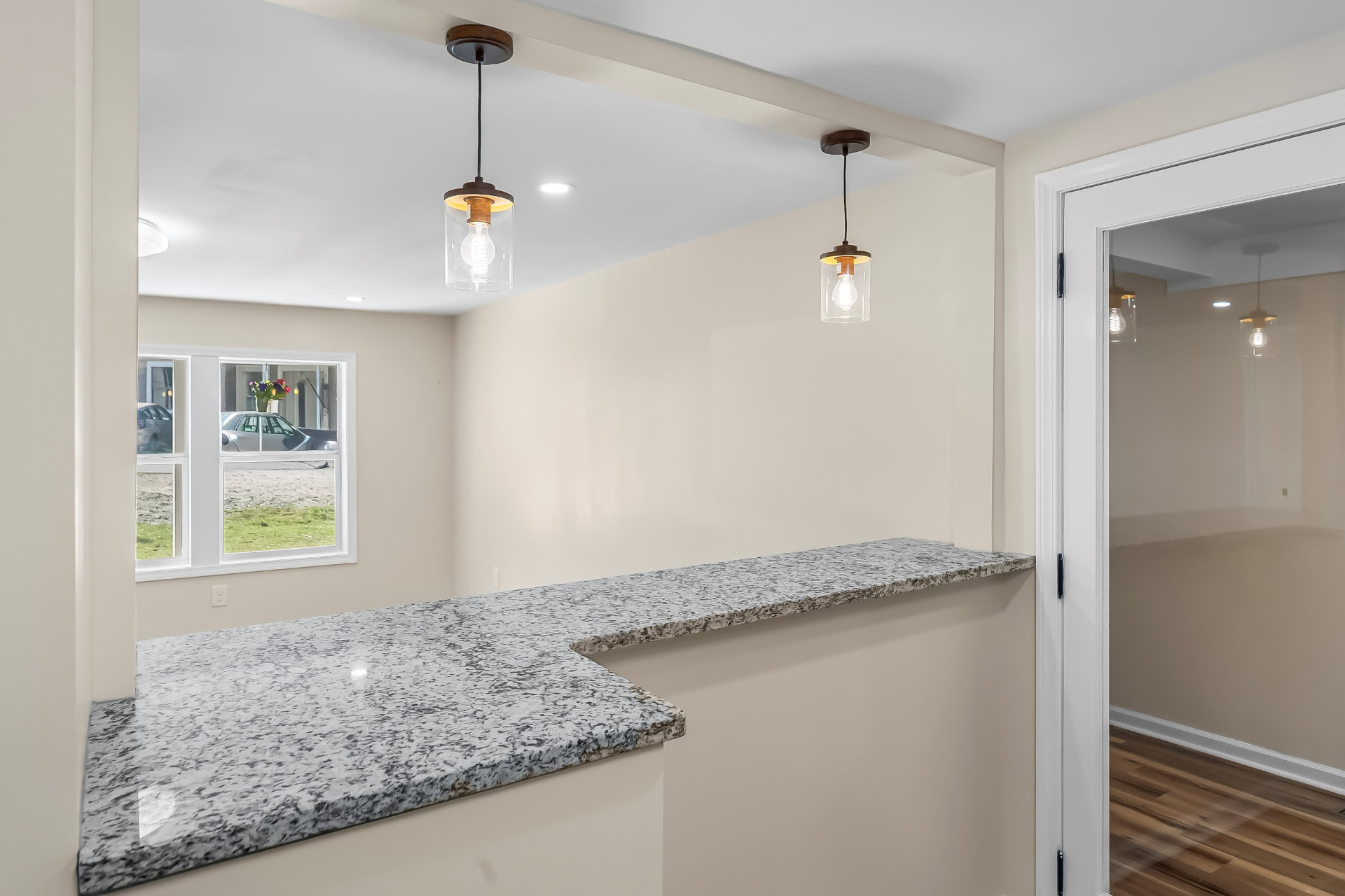 Peninsula counter and pendant lights between the kitchen and dining area