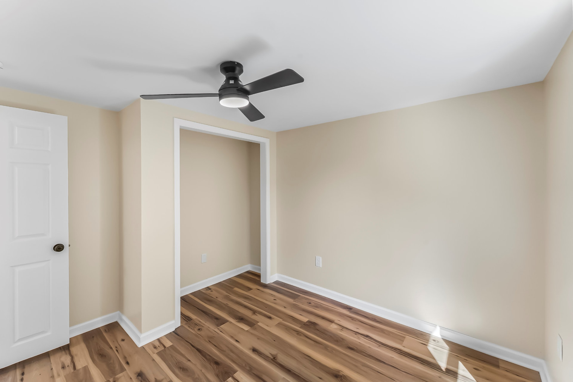 Freshly painted bedroom with closet nook and modern black ceiling fan